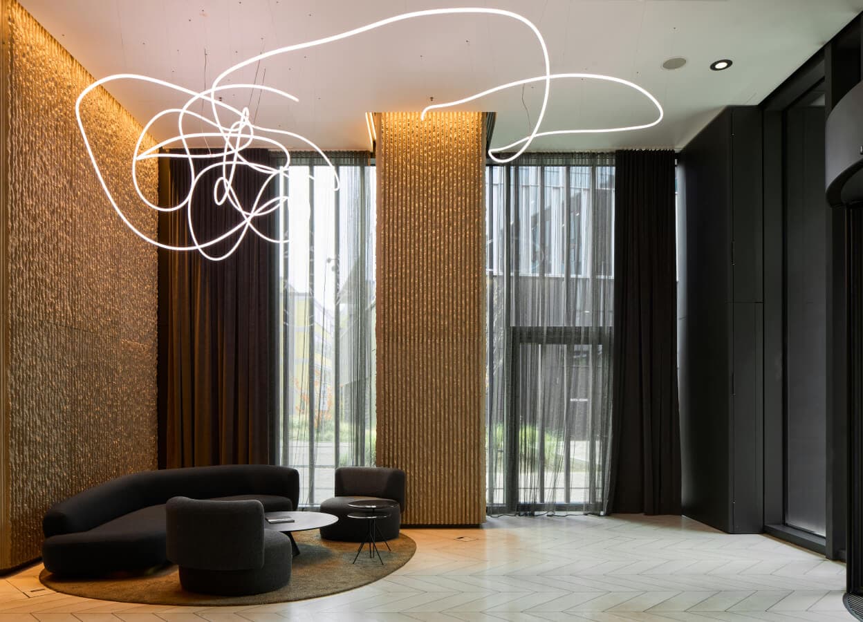 Lobby des ONE FORTY WEST in Frankfurt mit skulpturaler Neon-Lichtinstallation — Innenausbau von ConstructionX